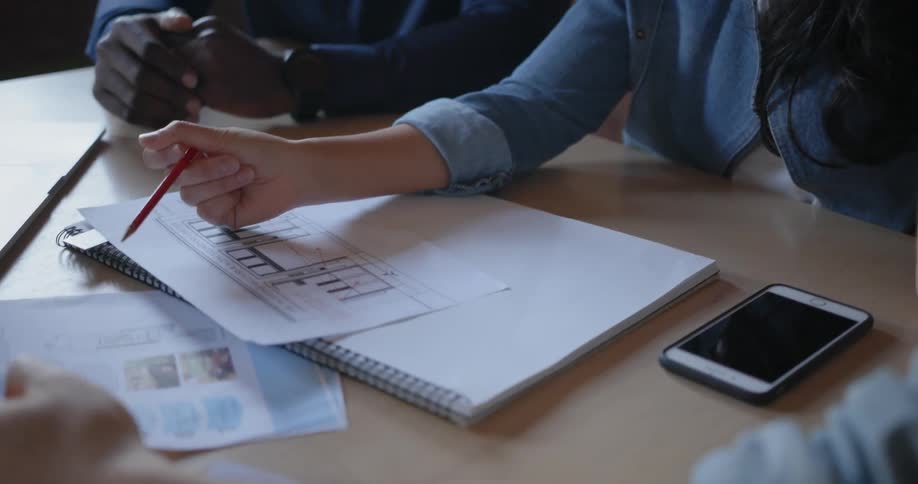 People sit in a conference room looking at papers