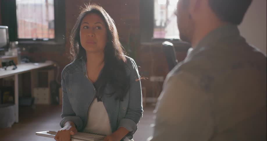 A man and a woman sitting and chatting with another person