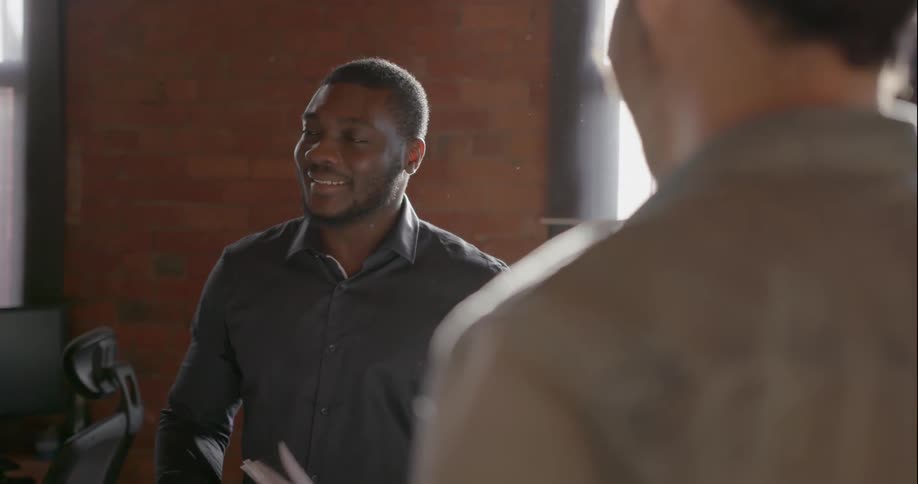 A man is talking with someone in an office