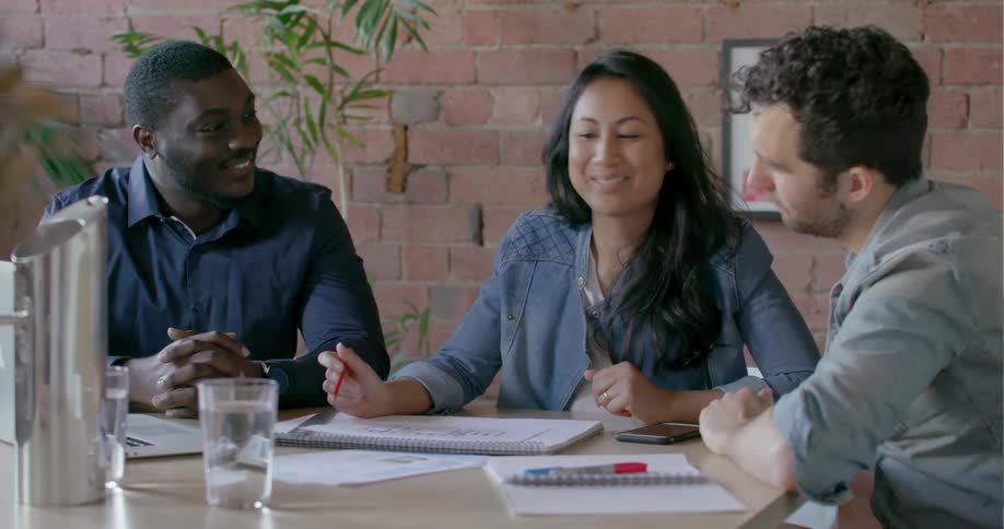 Employees sit at a table to work together