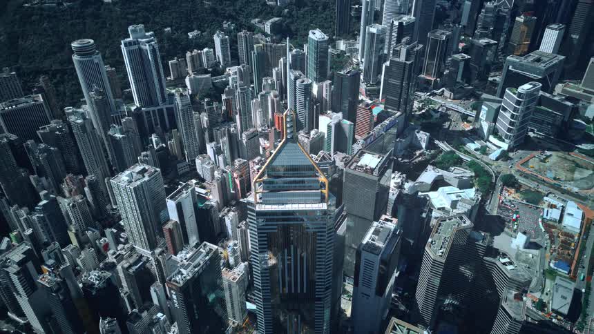 Timelapse of a very dense urban city features numerous tall skyscrapers with one distinctive triangular top building in the center