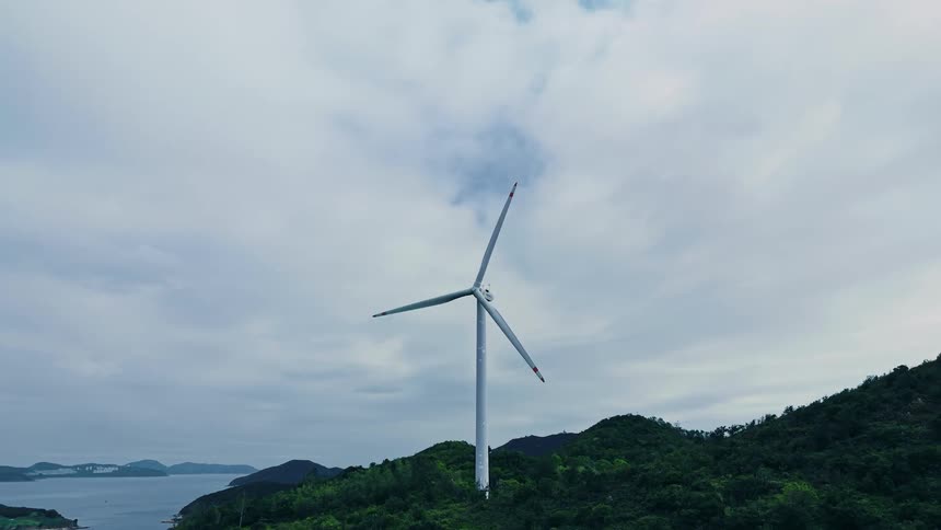 A rotating windmill outdoors in a rural area during daytime