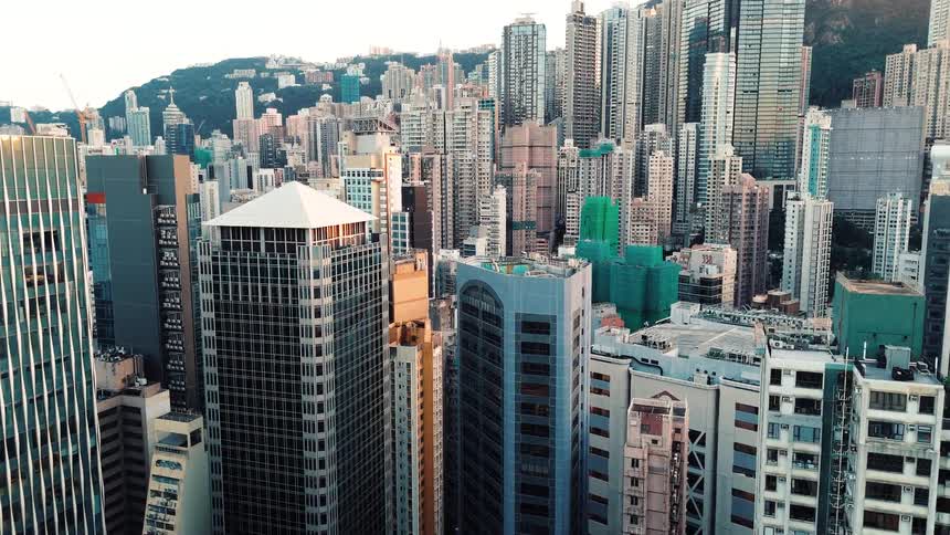 Drone Flying Over Dense Skyscrapers in a Financial District in Hong Kong