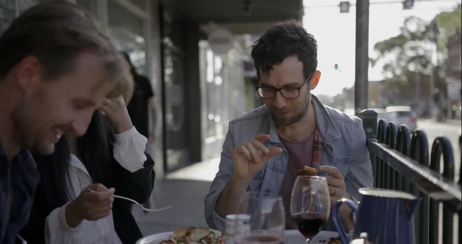 People dine at at outdoor table in a city