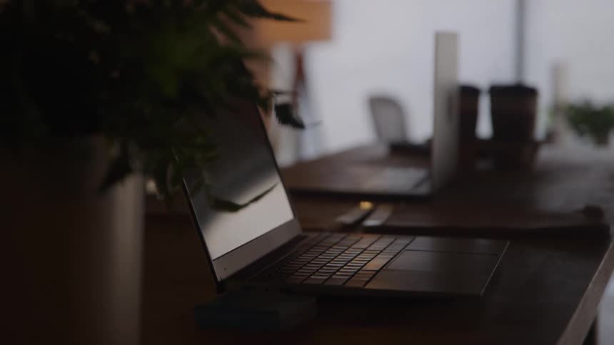 Laptops are set up on a desk in an office