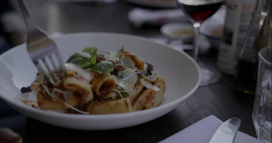 A person forks some food in a dish