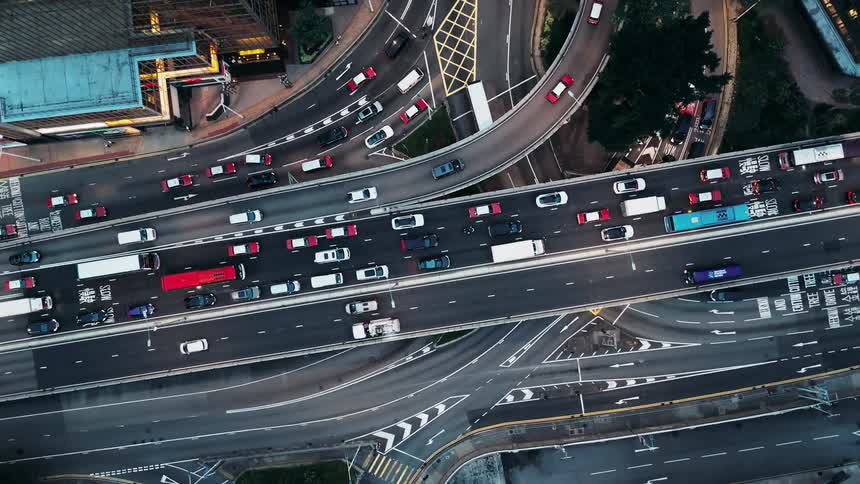 Heavy traffic is moving on several roads of a highway interchange in a city
