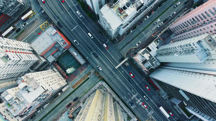 Traffic is moving on city streets next to skyscrapers