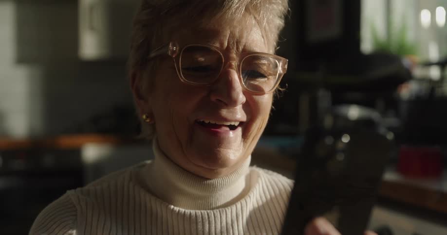 Elderly woman holding a phone in an indoor setting