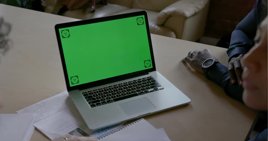 People sit around a laptop