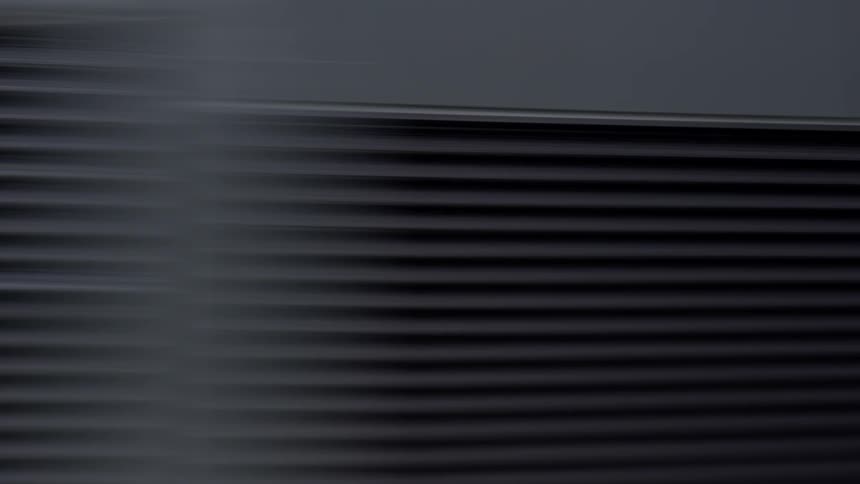 A camera whips rapidly past the black horizontal slats of a buildings exterior