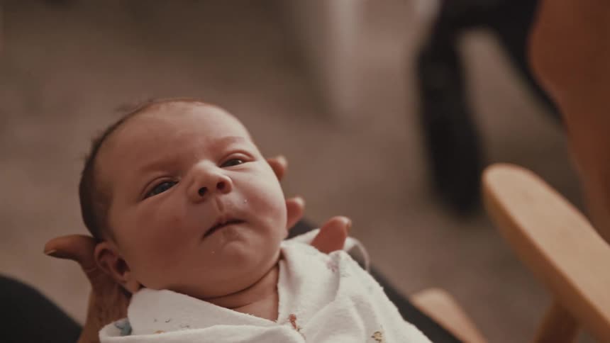 Grandmother holding her newborn grandson and smiling