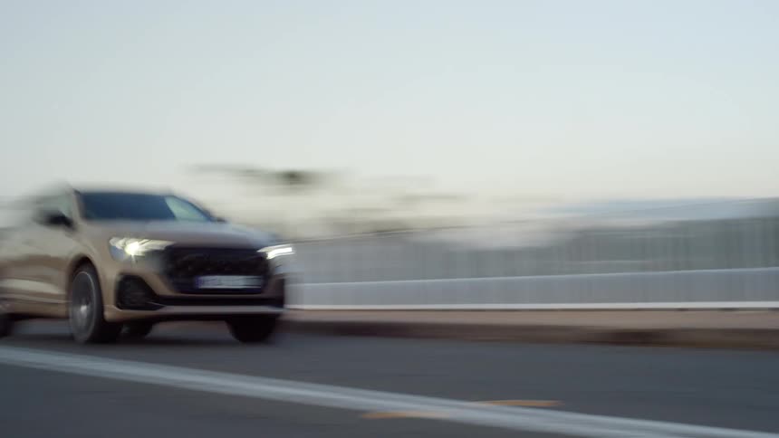 A car accelerating on a road in an urban city during daytime