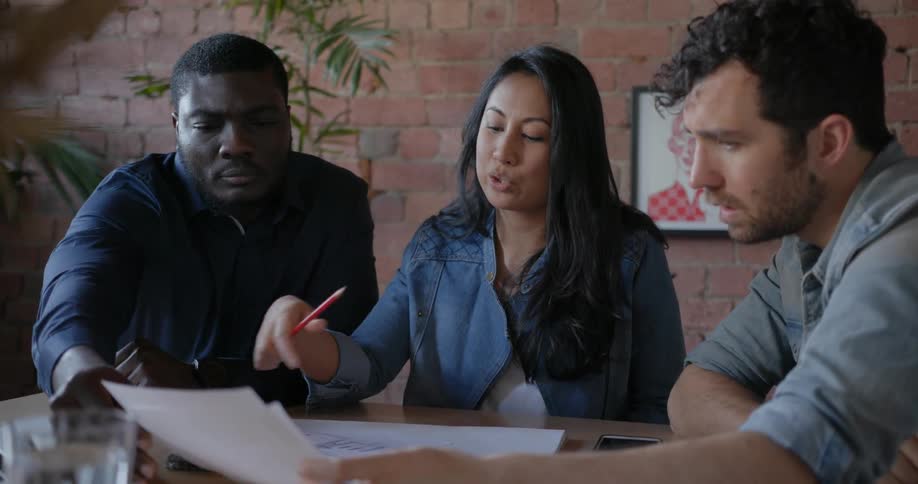 People sit at a table looking over some papers