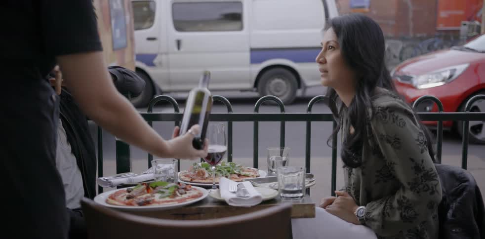 A man and woman dine on a restaurant patio