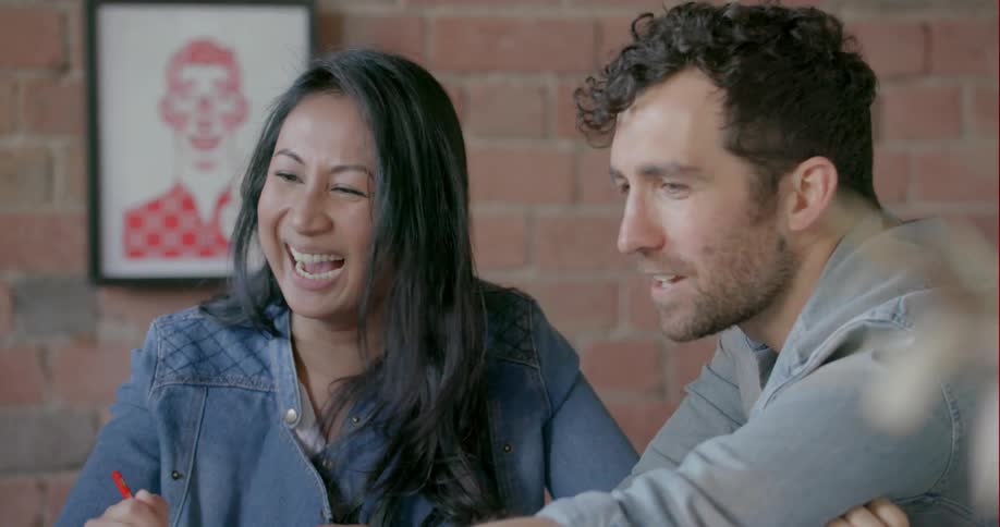 A man and woman smile and laugh