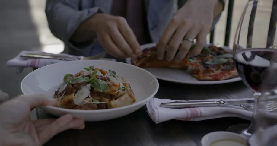 People are served food at a restaurant table