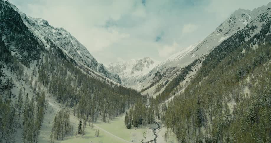 An aerial view of a mountain range in the winter and summer