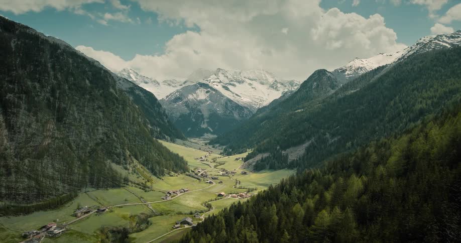 Rivers run through a valley between mountains as the seasons change from winter to spring