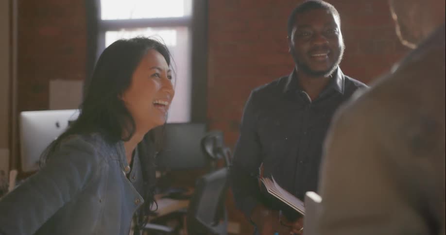 People stand in an office together talking and laughing