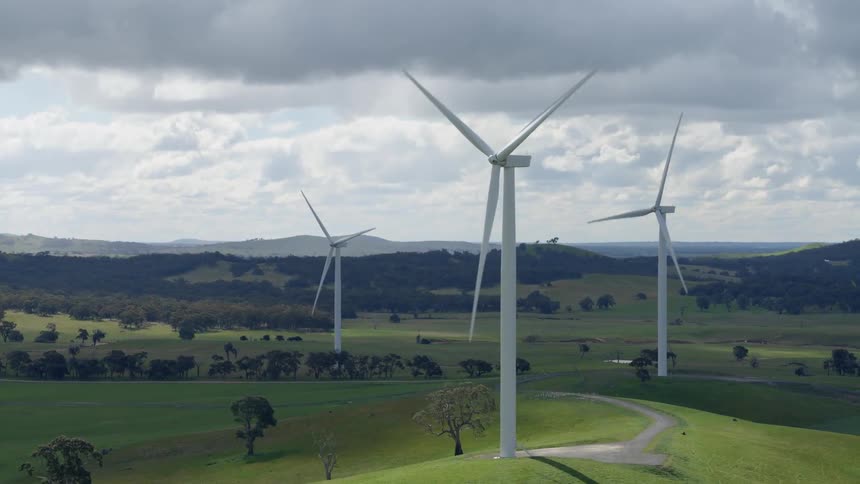 Wind turbines move on a hilly area