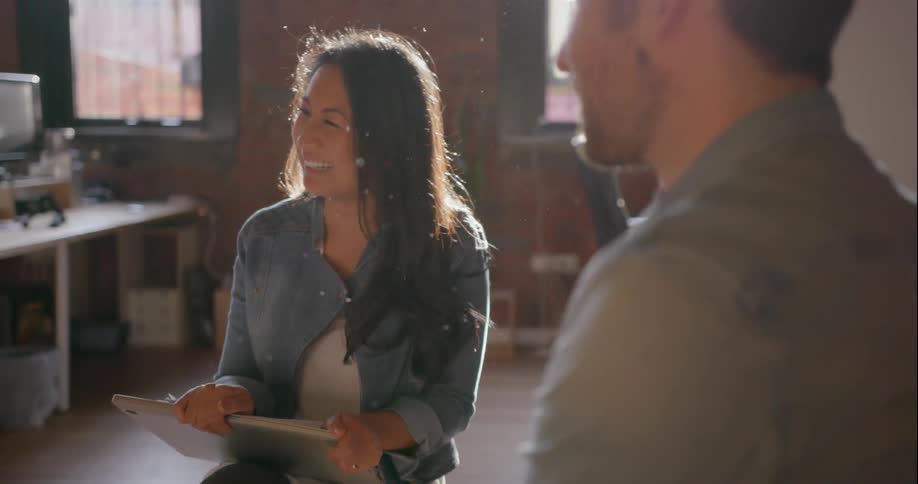 A man and woman laugh in an office setting