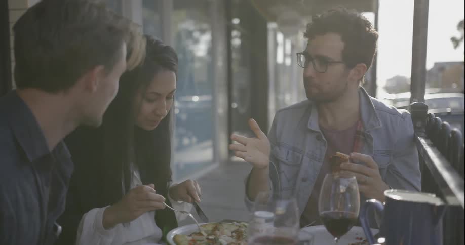 People sit to a meal outside and talk