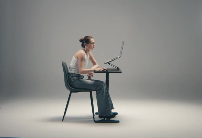 The woman is using a mouse with her laptop