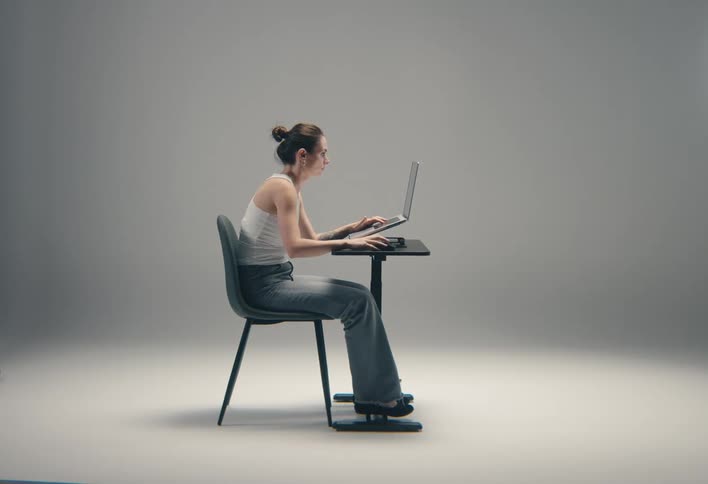 Woman leaning forward while typing on a laptop