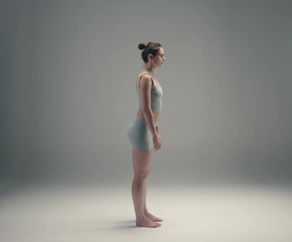 Woman wearing matching shorts and a top stands motionless