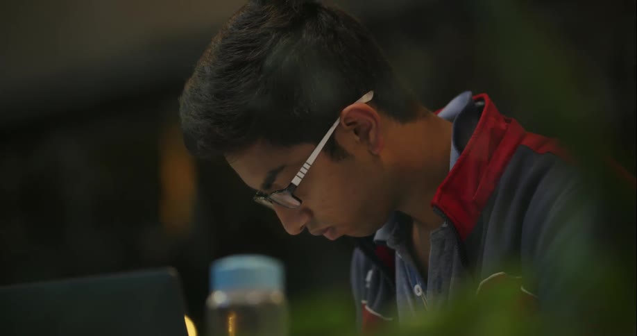 A man works at a table with a laptop