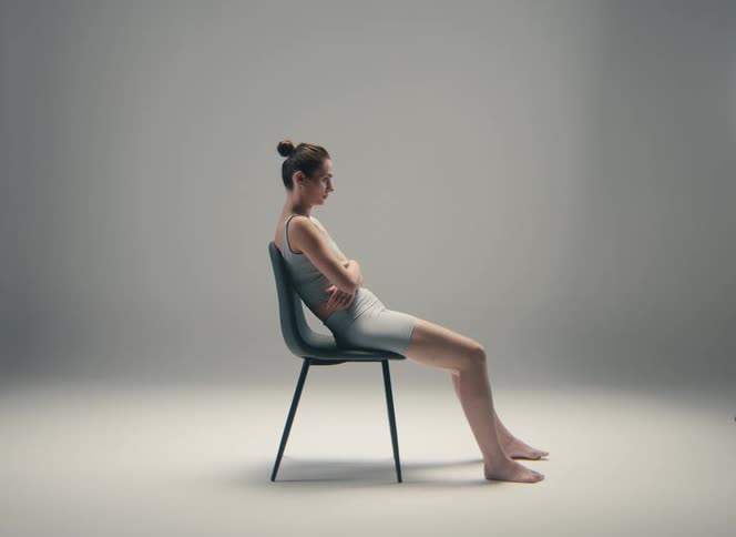 Woman sits slouched in a chair in a nearly empty room