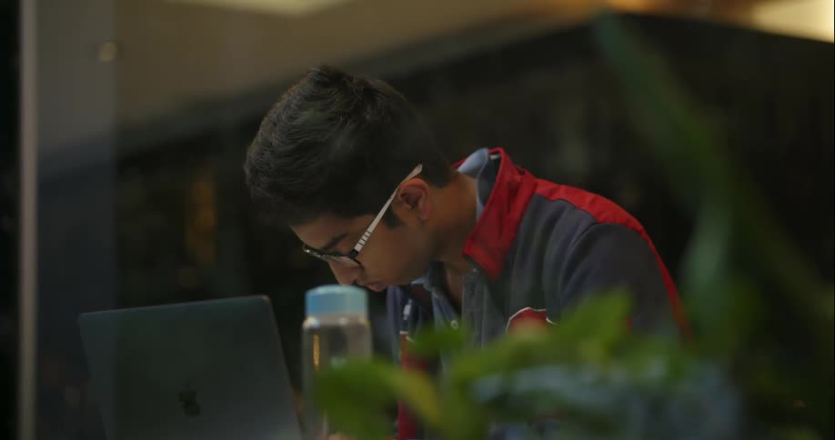 Teenager sitting at a laptop studying