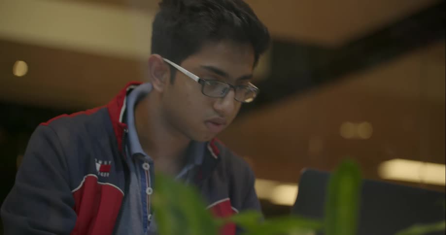 A man is writing and looking at a computer