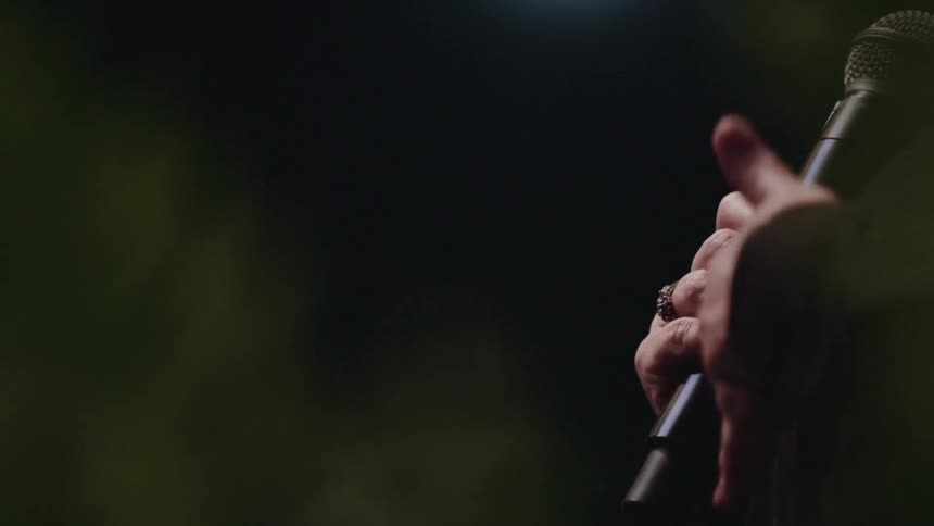A woman holds and speaks into a microphone