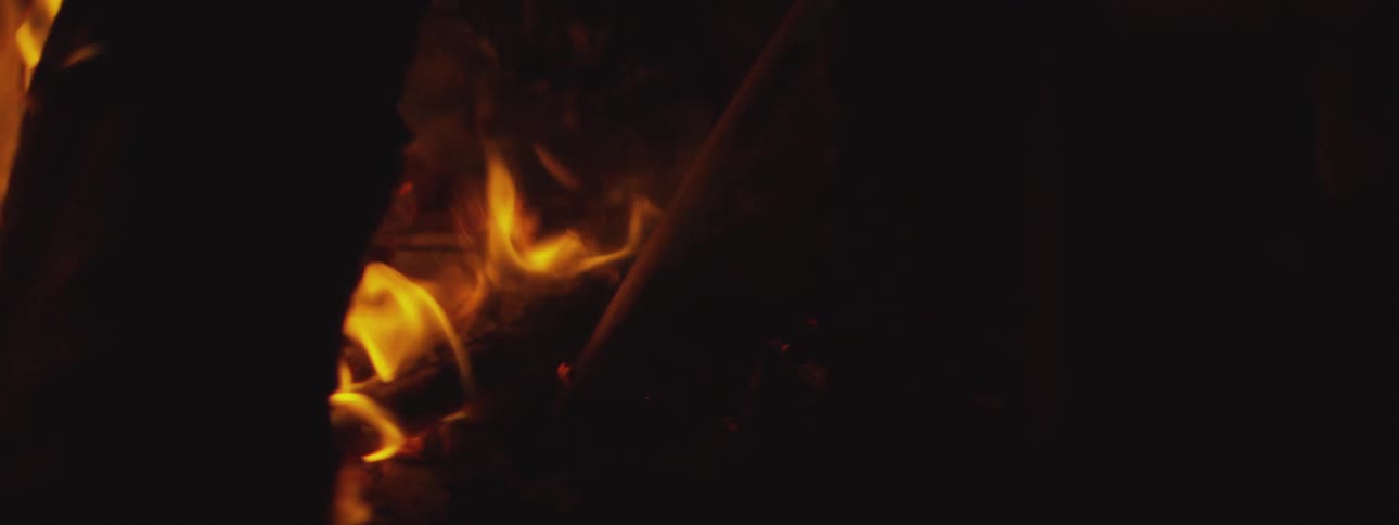 The incandescent orange flames of a bonfire in a partially dark place