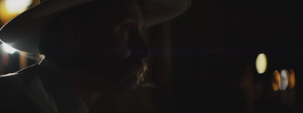 A portrait of a man sitting outdoors at night