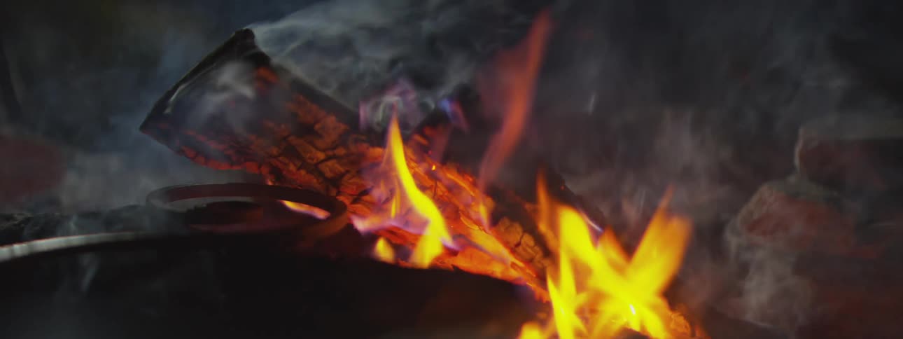 A view of some wood burning outdoors at night