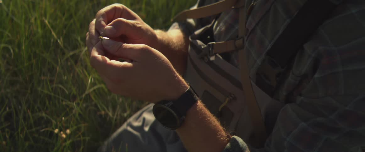 The man ties a lure on the fishing line