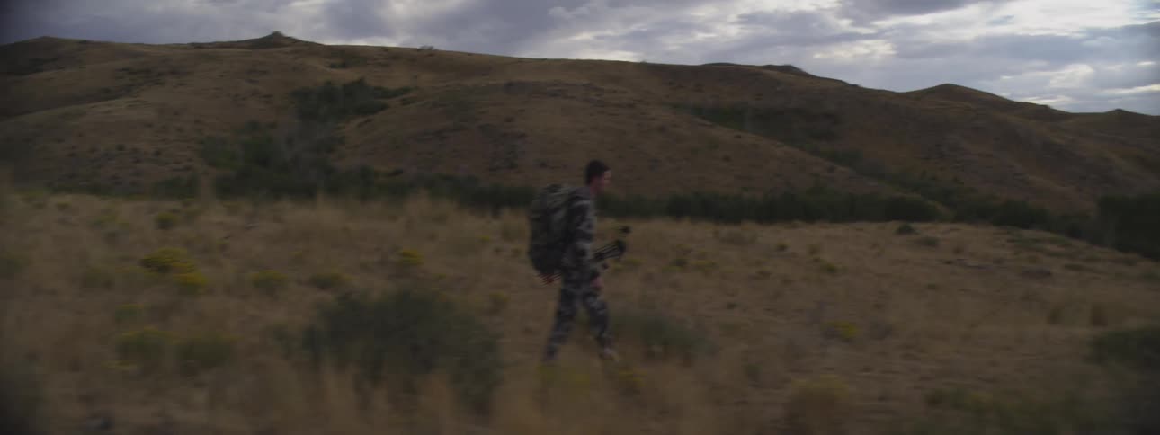 Man wearing a backpack hikes across the desert
