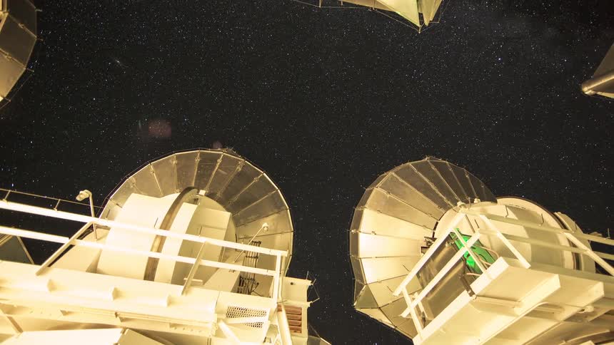 Telescopes pointed toward the starry sky seen from a low angle