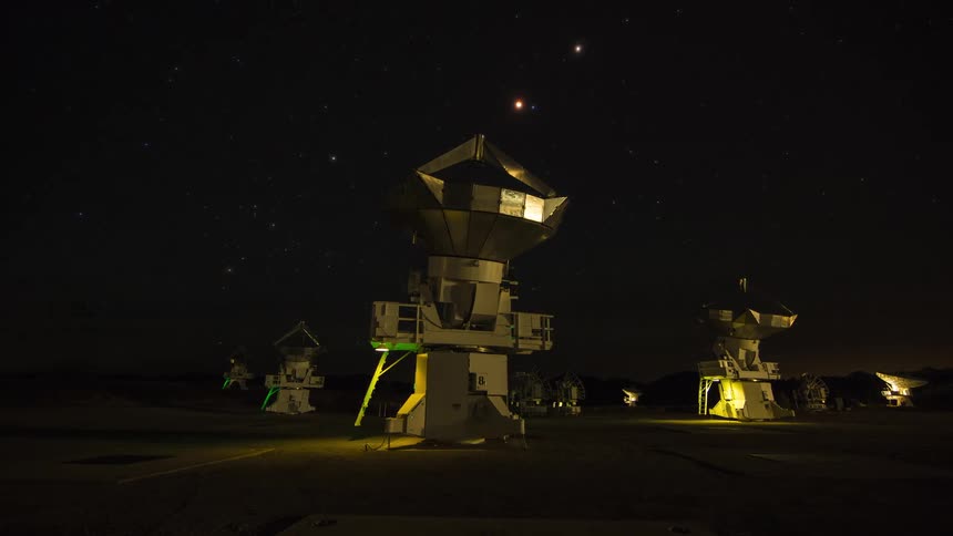 Radio telescope satellite dishes in the desert turn and move under stars and clouds in the sky from night to day