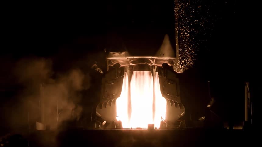 Rocket fuel glows in the darkness as a rocket takes off from the launching pad