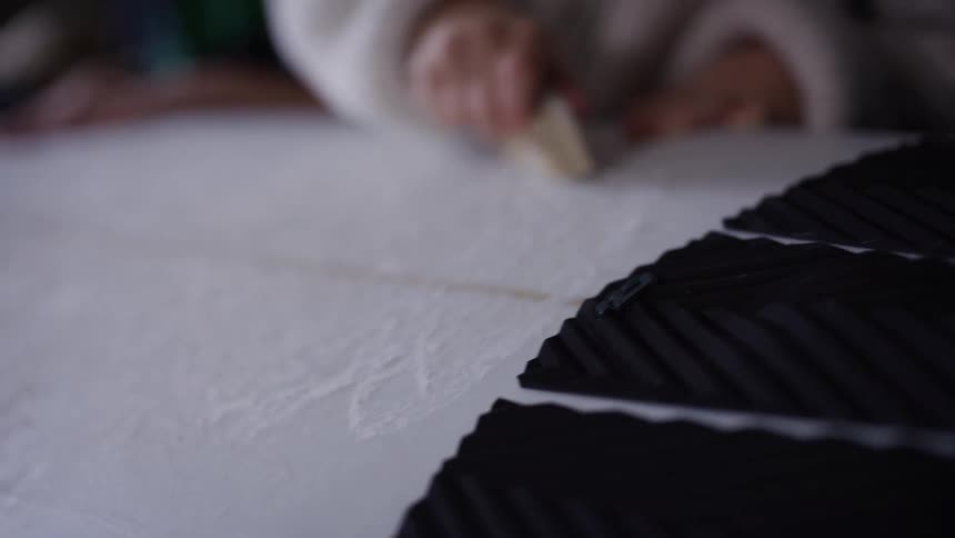 Childs hand applying wax on the surface of a board
