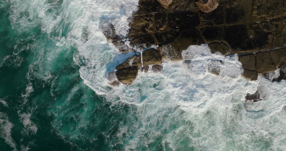 Waves crashing onto rocks outdoors