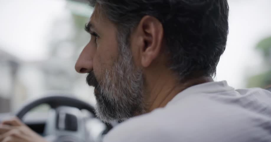Graybearded man driving while looking at the road