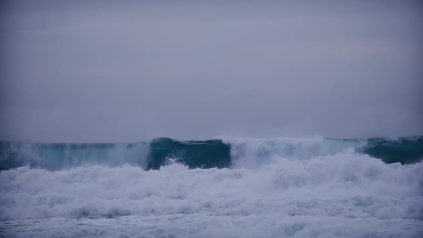 Waves splash and curl as they roll in to shore
