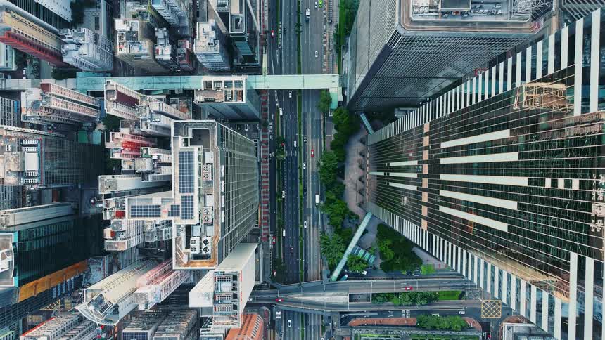 A top down aerial shot travels over busy city streets lined with dense business buildings