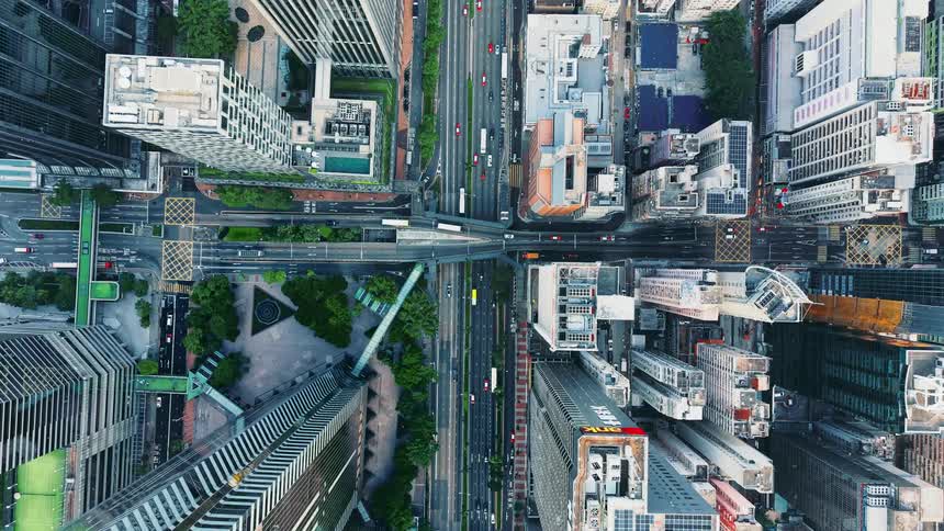 Aerial view of metropolitan towers and skyscrapers as traffic moves on the city streets