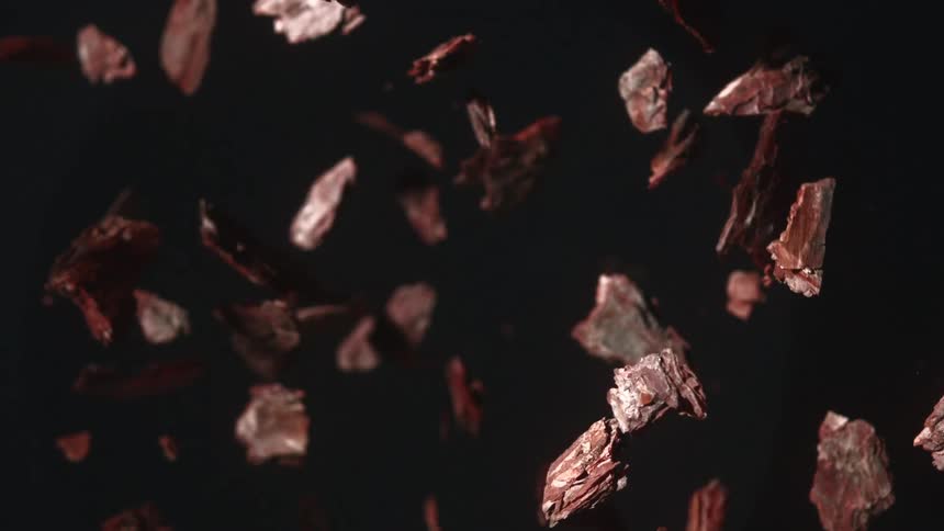 Brown solid fragments suspended against a black background